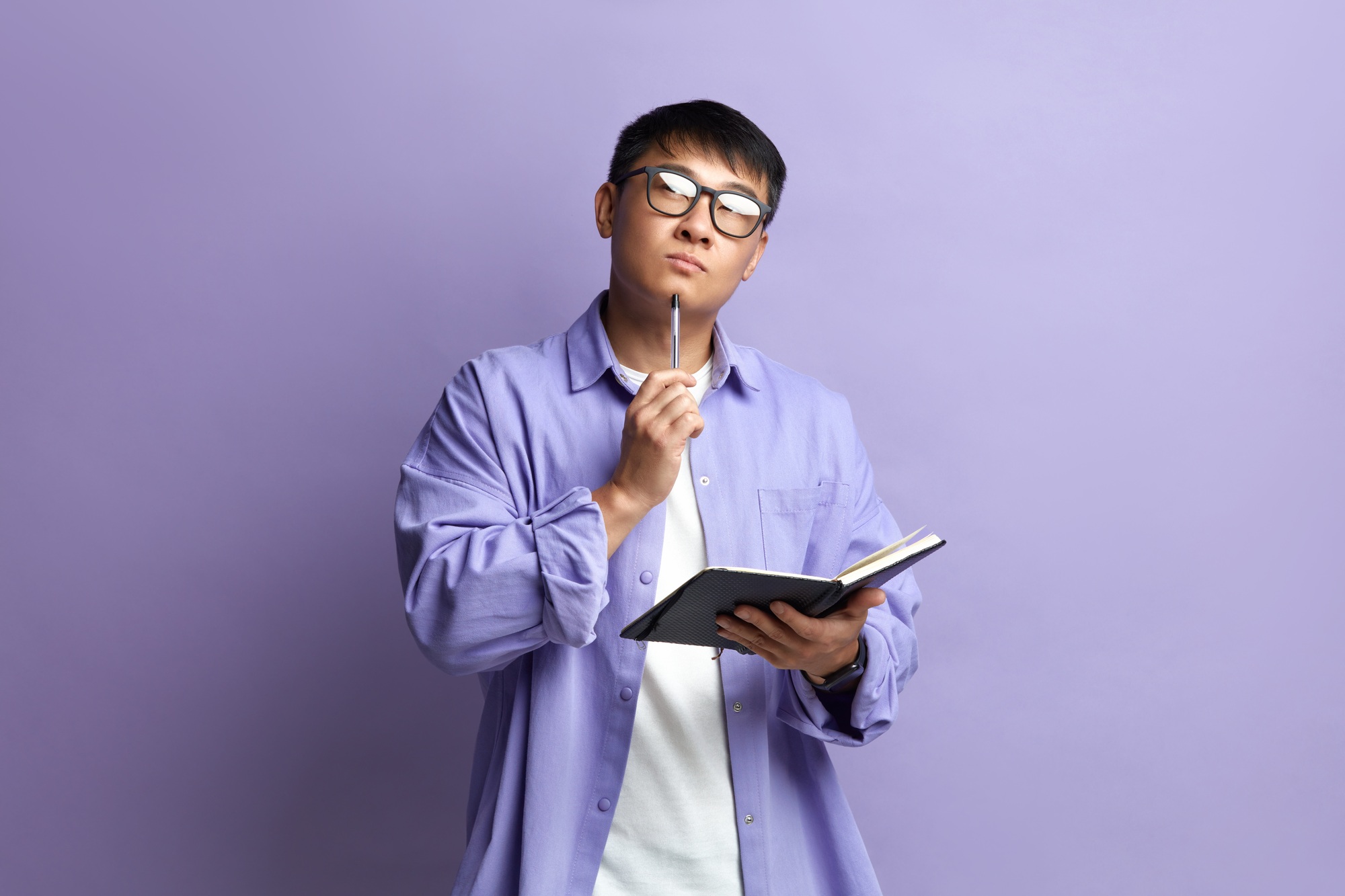 Asian Man Writing Notebook. Portrait of Guy Making Notes in Paper Notebook